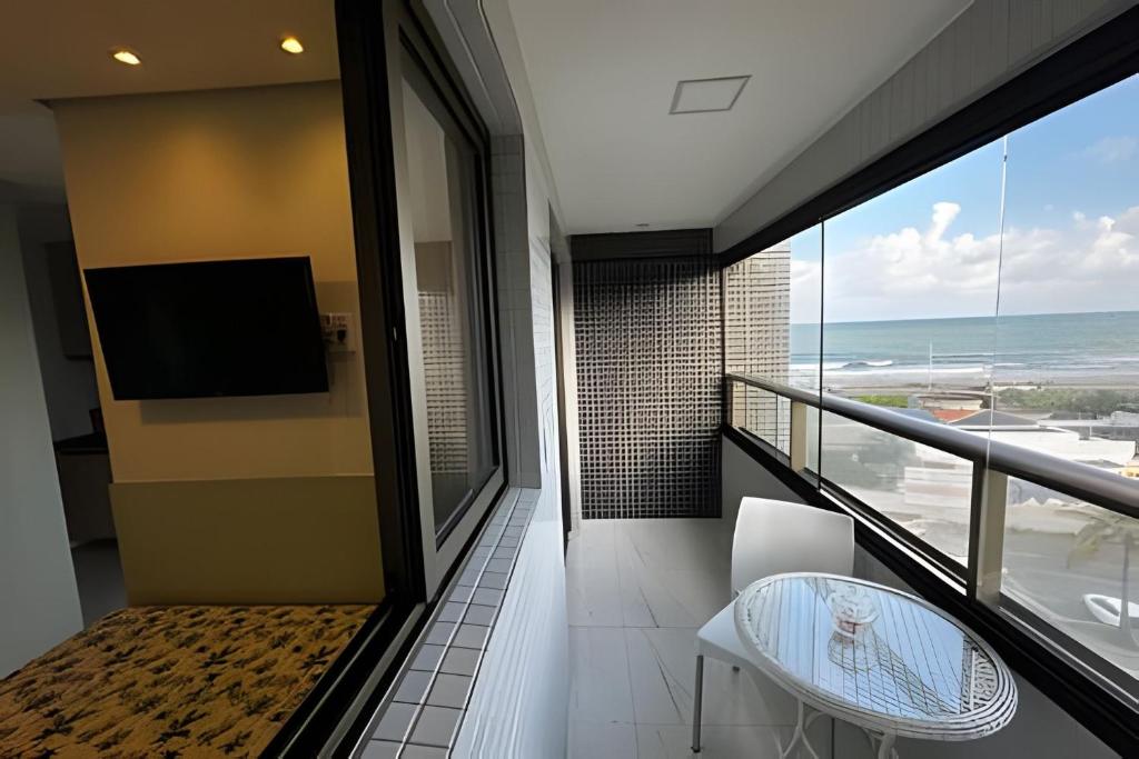 a balcony with a table and a view of the ocean at Para quem deseja conforto e bem estar in Salvador