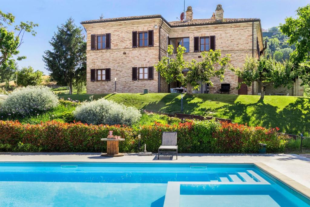 a villa with a swimming pool in front of a house at Villa La Fonte 14 in Ripatransone
