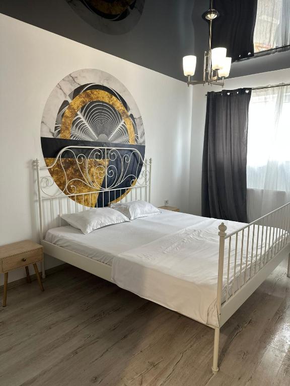 a bedroom with a bed with a painting on the wall at Studio Luna in Chiajna