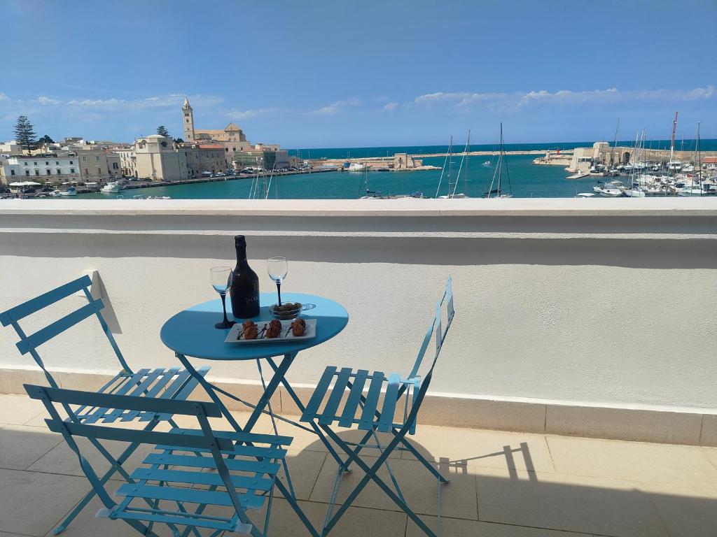 Una mesa y sillas en un balcón con vista al agua. en CconfortHotels Sea Dream Palace 2, en Trani