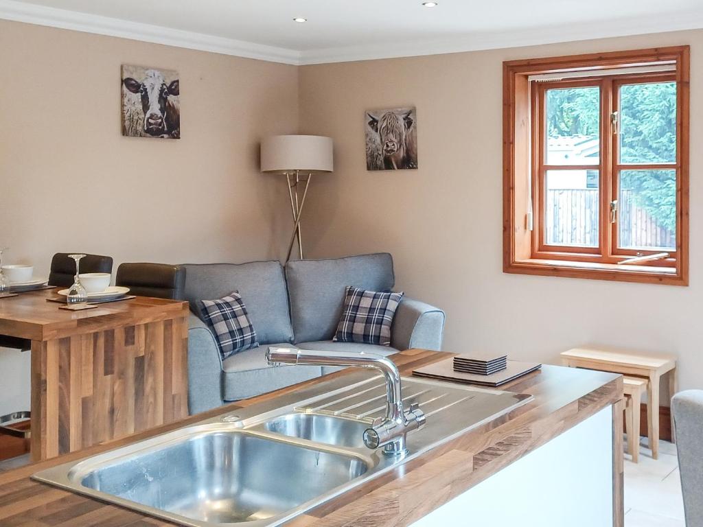 a kitchen and living room with a sink and a couch at Alfie's Abode in Ingoldmells