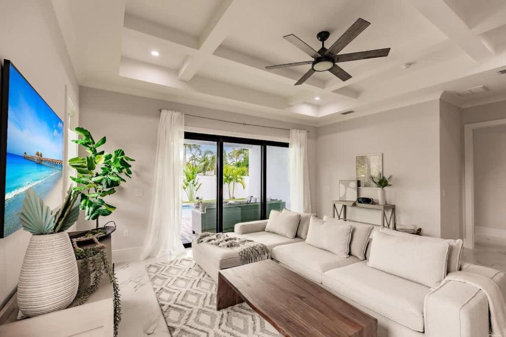 a living room with a white couch and a ceiling fan at Luxury Naples 4br W Pool Near Vanderbilt Beach in Naples