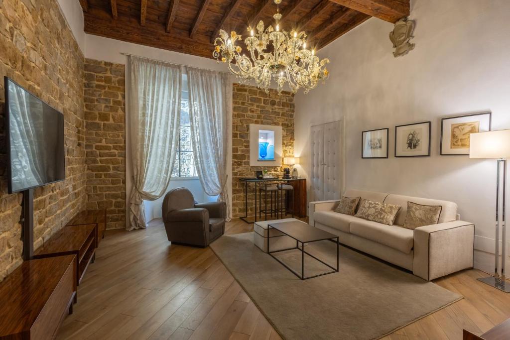 a living room with a couch and a brick wall at Donati Luxury Tower Suites in Florence