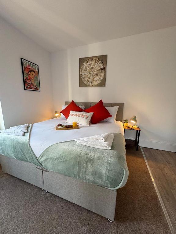 a bedroom with a large bed with red pillows at Central Peterborough Studio 2 in Peterborough