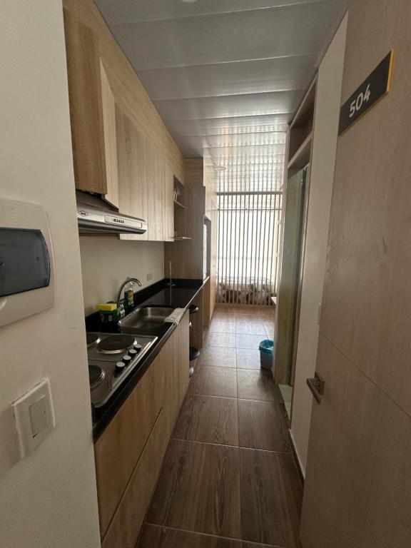 a kitchen with wooden cabinets and a long hallway at Castellana 504 in Bogotá