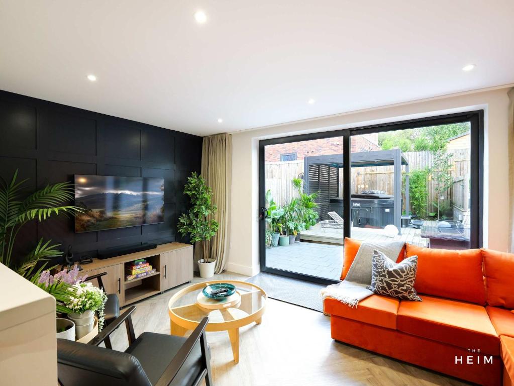 un soggiorno con un divano arancione e una TV di Eden at The Heim Residences a Manchester