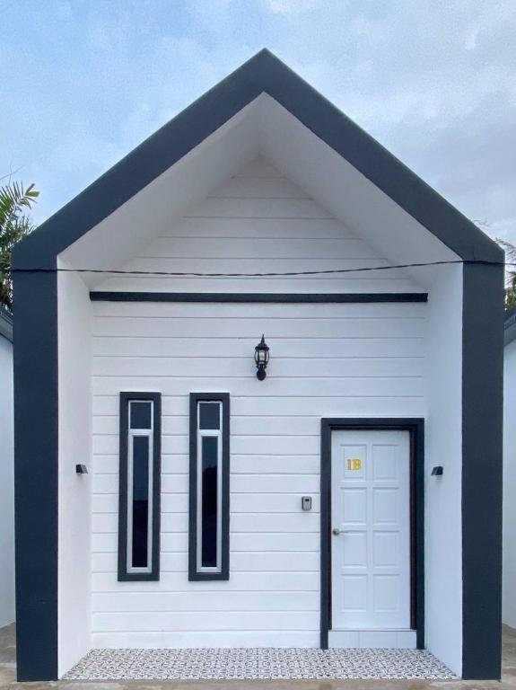 a white garage with a black roof and a door at AZ Roomstay Pendang in Pendang