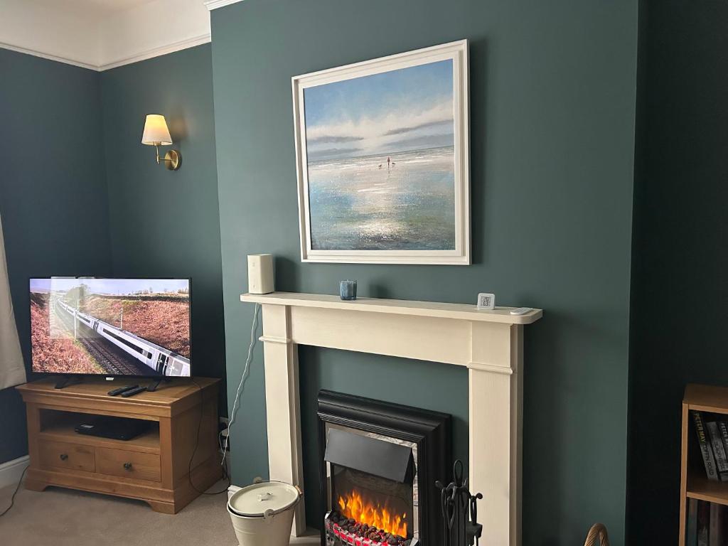 a living room with a fireplace and a painting at Stornoway Townhouse in Stornoway