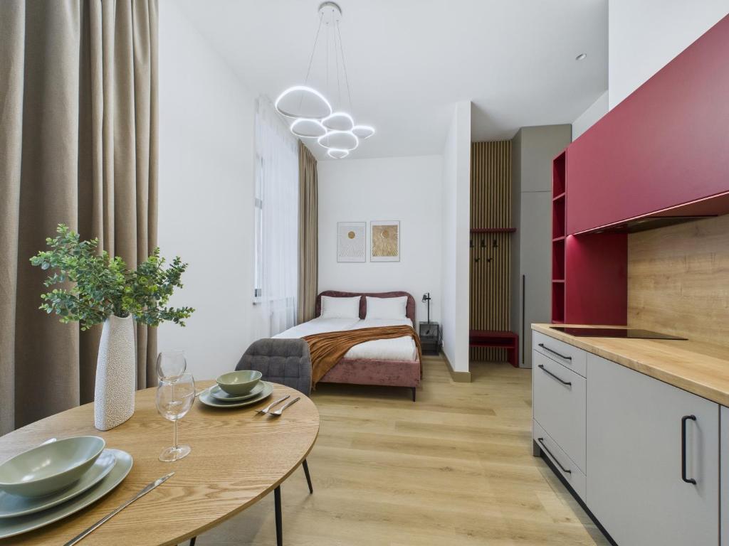 a room with a bed and a table in a room at M4 Modern City Centre Studios - 3 min Central Station in Riga