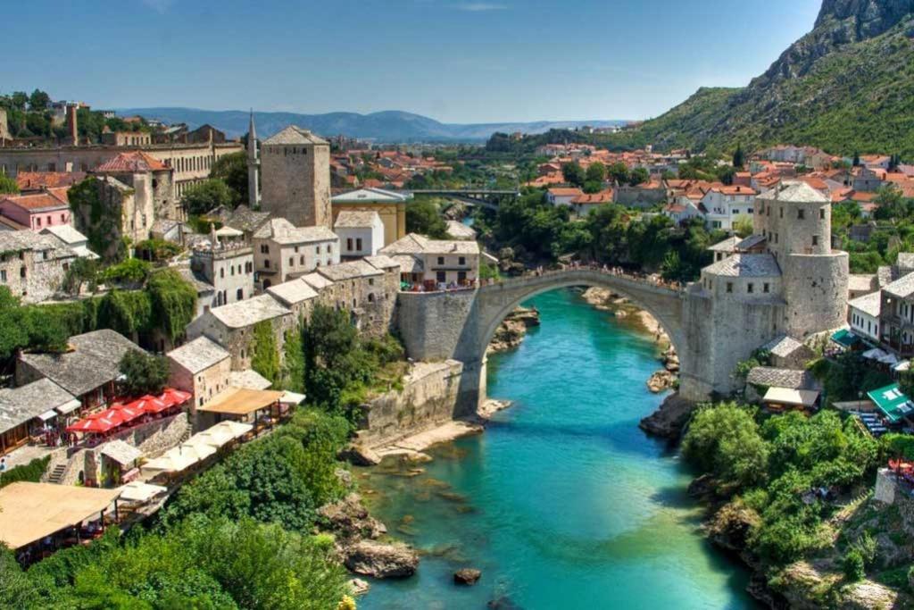 an old bridge over a river in a town at Hostel Centrum in Mostar