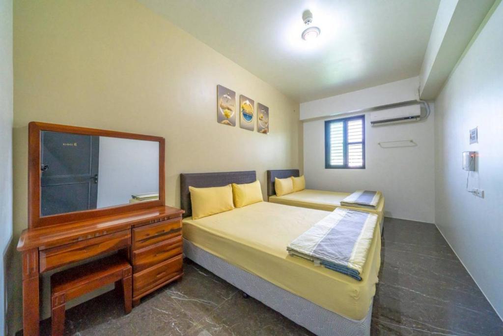 a bedroom with a bed with a dresser and a mirror at 自在如家獨棟民宿 in Toucheng