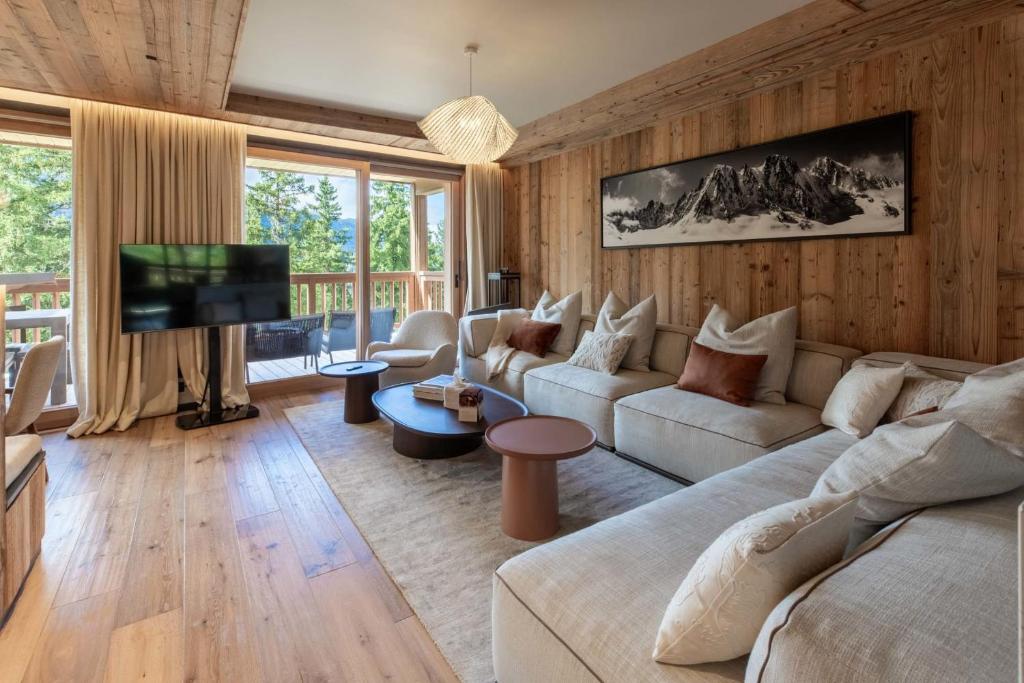 een woonkamer met een bank en een tv bij Antarès ORION 201 - luxury apartment ski inski out in Méribel
