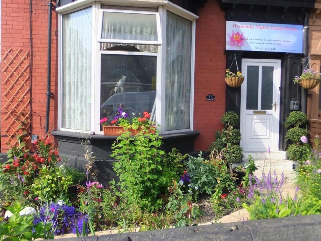 a house with flowers in front of a window at Heavenly Nights Guest House in Sheffield