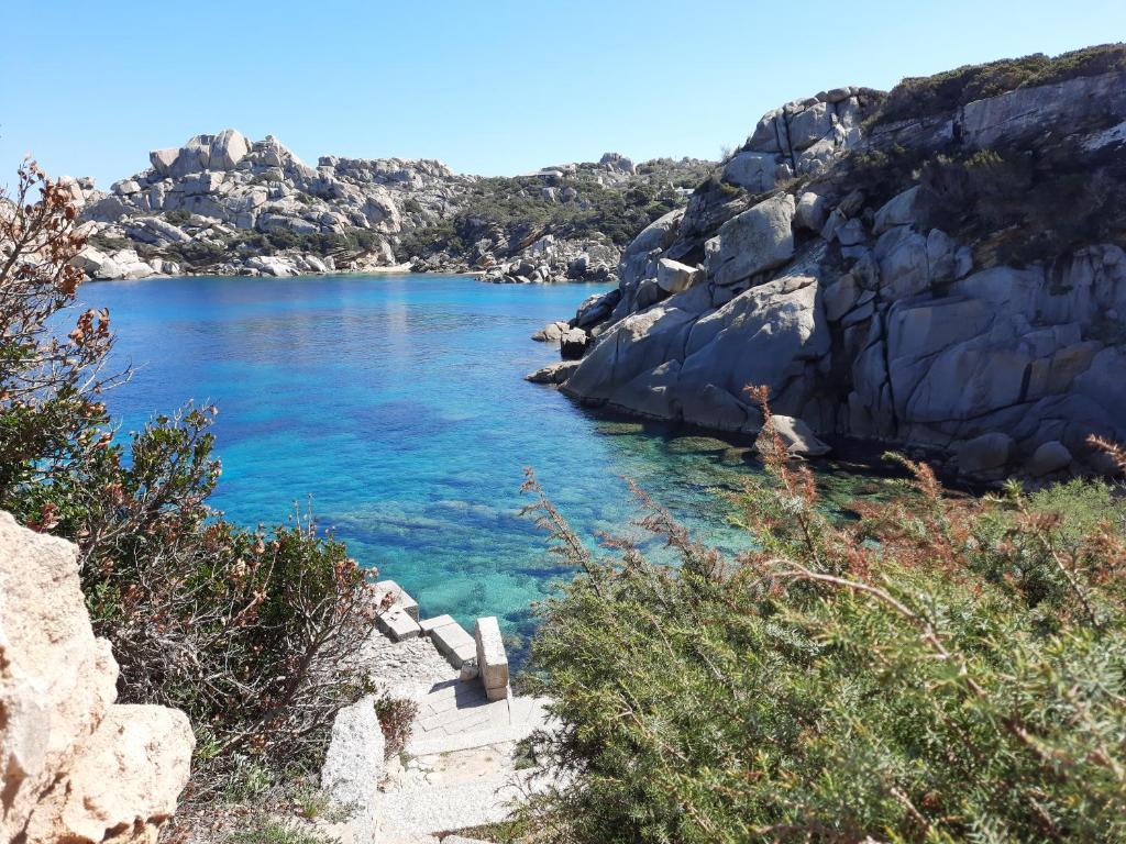 a view of a beach with blue water and rocks at Case del centro storico Santa Teresa Gallura in Santa Teresa Gallura