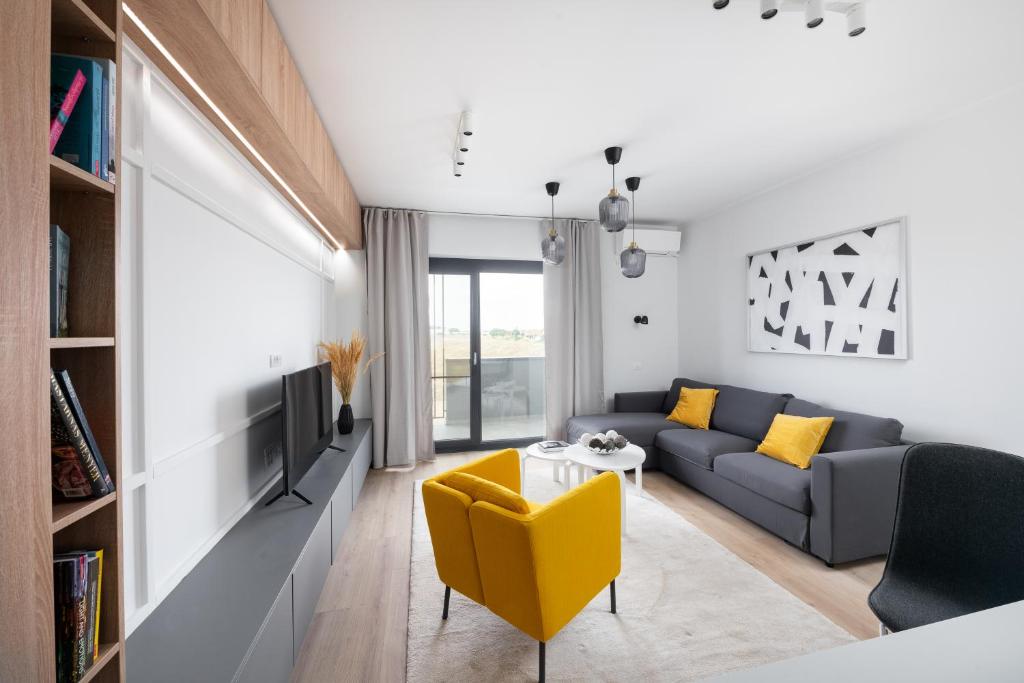 una sala de estar con un sofá y una mesa en Aris Apartments - free parking - powered by NEO, en Dumbrăviţa