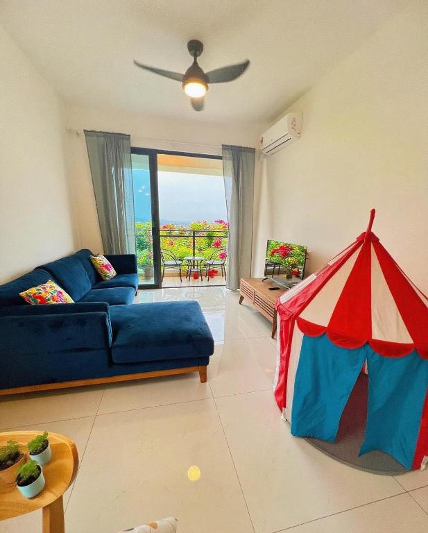 Una sala de estar con un sofá azul y una tienda de juegos. en The Clover Homestay 4, en Gelang Patah