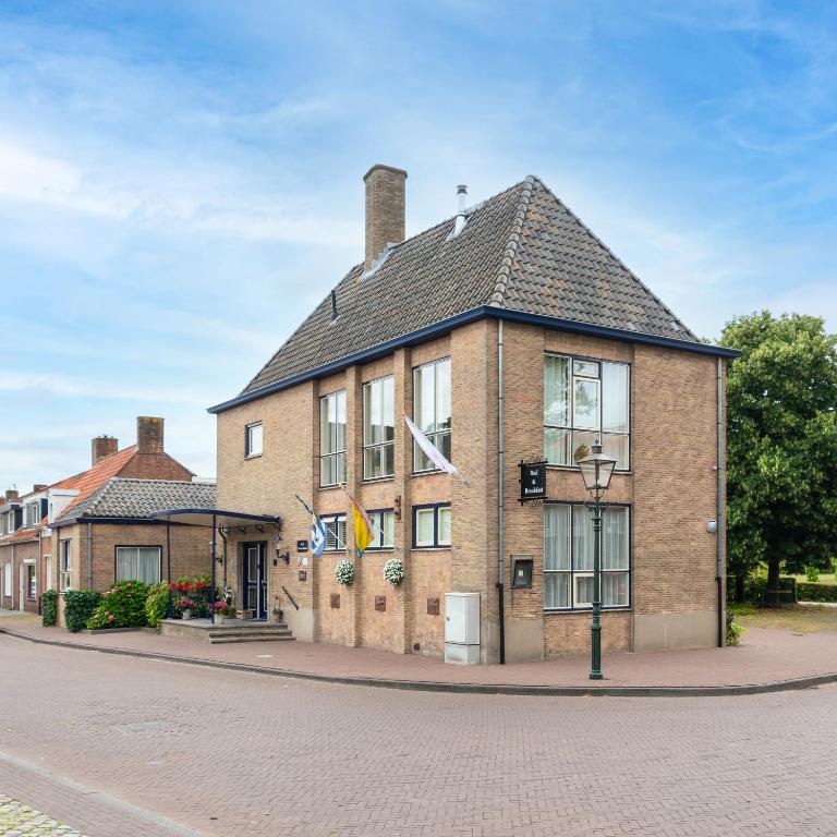a large brick building on a city street at B&B 't Gemeentehuis in Biervliet