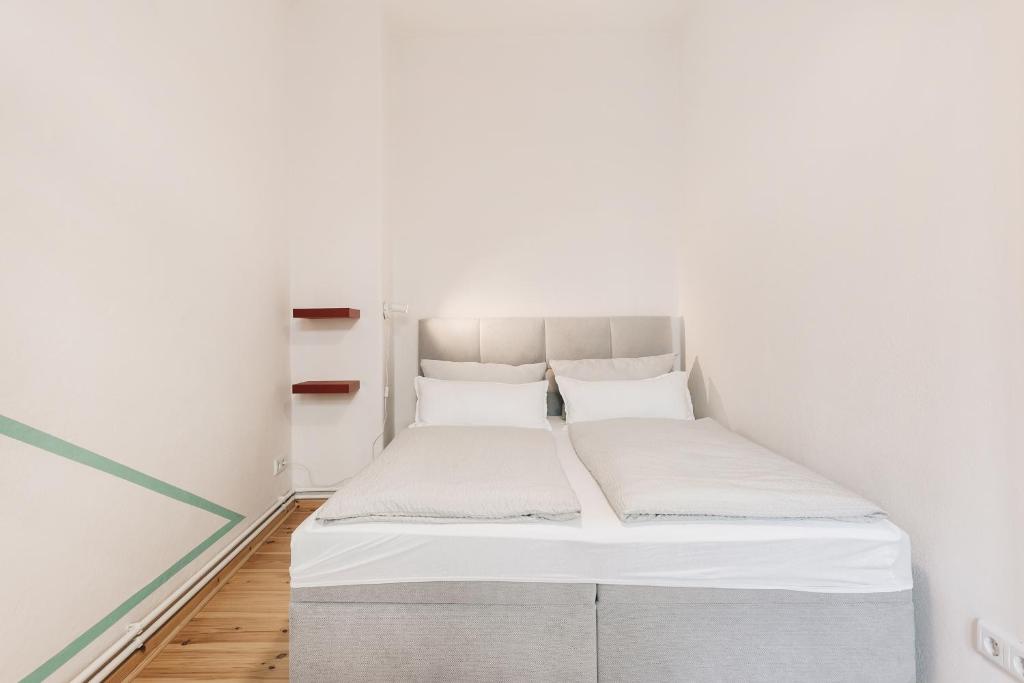 uma cama num pequeno quarto com paredes brancas em Einzigartiges Design Apartment em Löbau