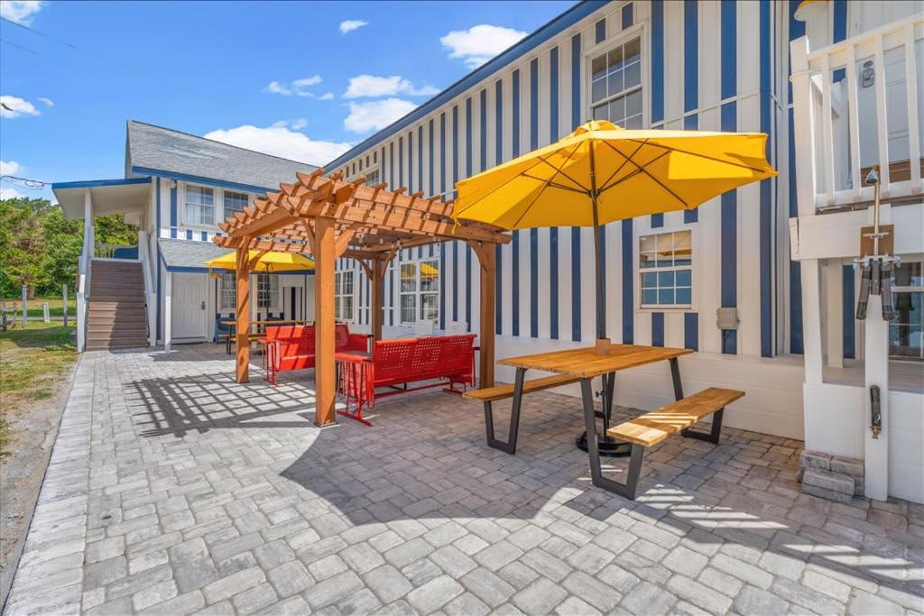 a patio with benches and umbrellas in front of a building at 2 bedroom Condo Steps from Beach Pet Friendly in Myrtle Beach