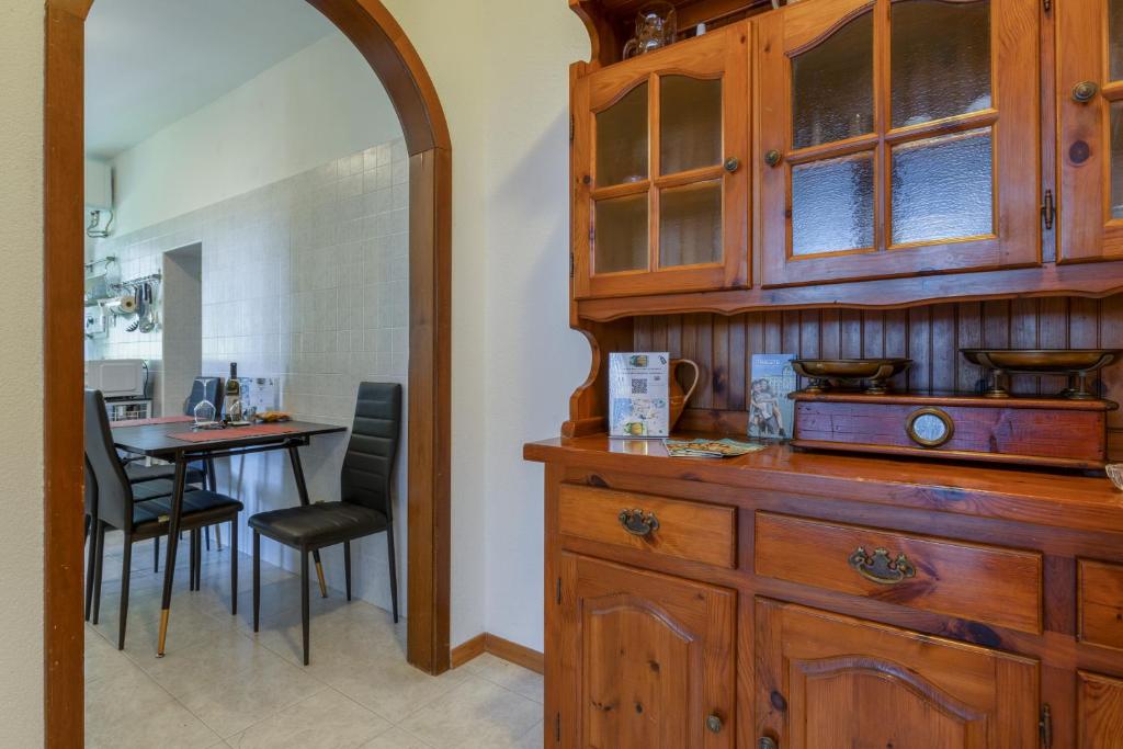 a kitchen with a wooden cabinet and a table with chairs at Vista&Capriccio in Trieste