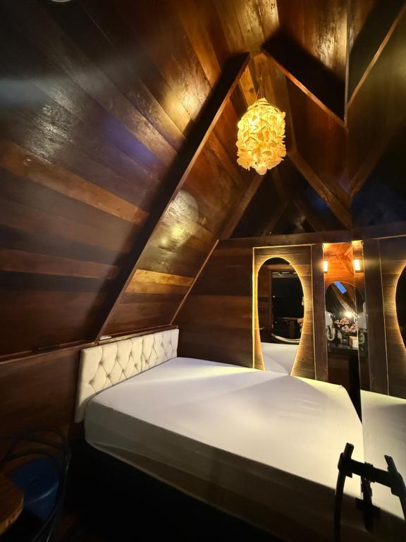 a bed in a room with a wooden ceiling at Chalés El Profesor in Saubara