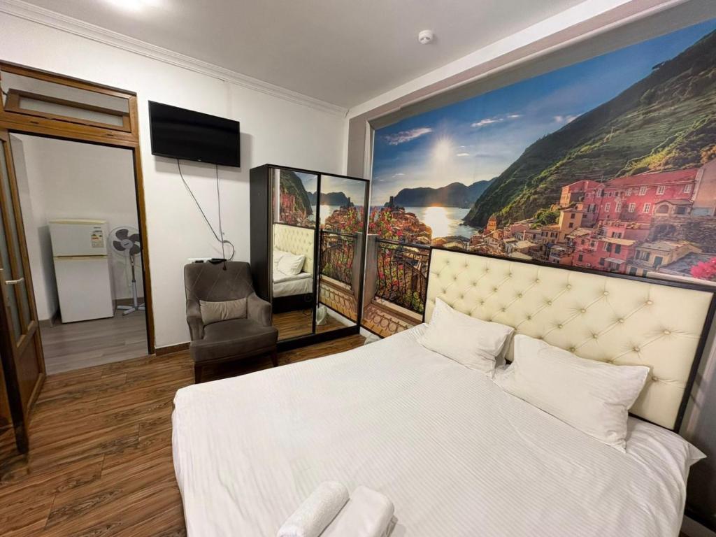 a bedroom with a large painting on the wall at Luxe Apartment Amiryan in Yerevan
