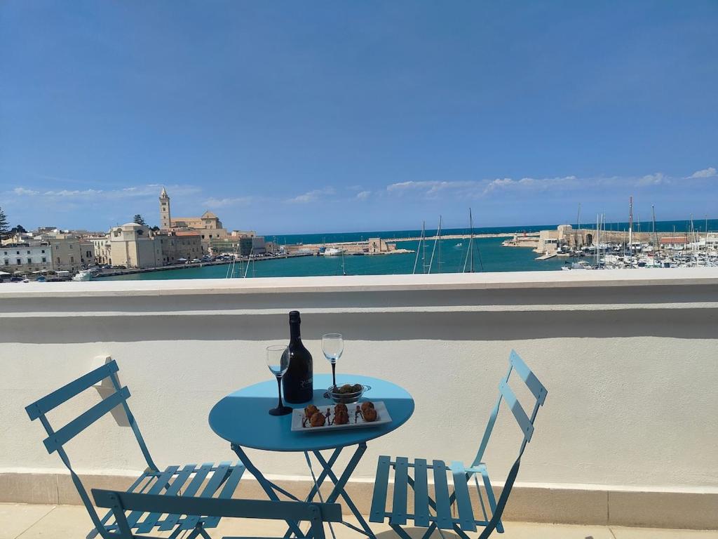 una mesa con 2 sillas y una botella de vino en el balcón en CconfortHotels Sea Dream Palace 3, en Trani