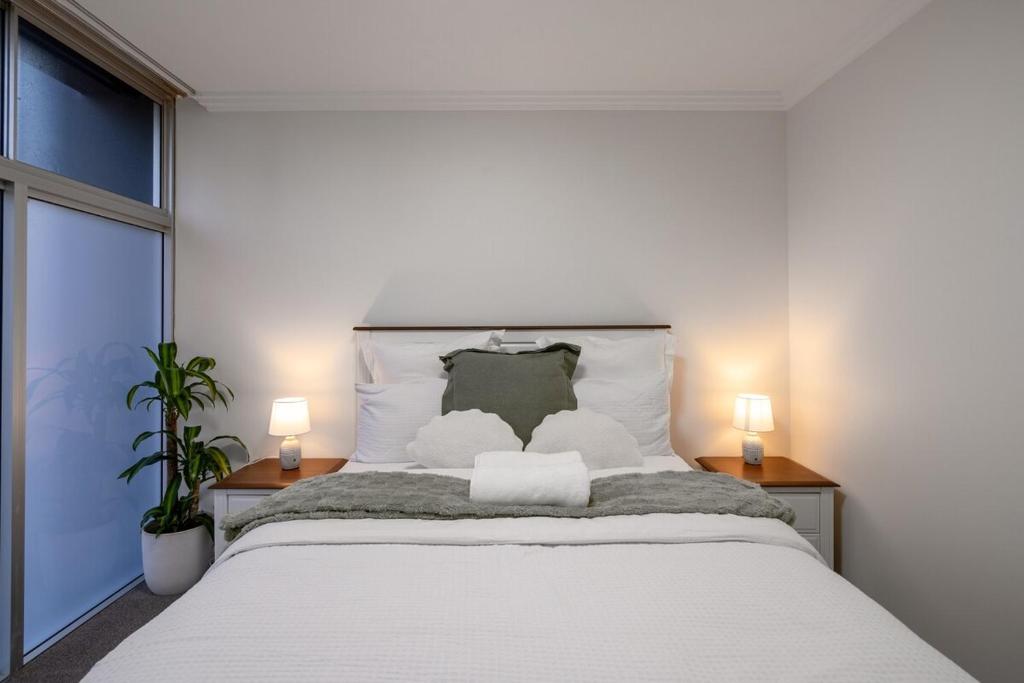 a bedroom with a large white bed with two lamps at Brisbane Central CBD convivence! in Brisbane