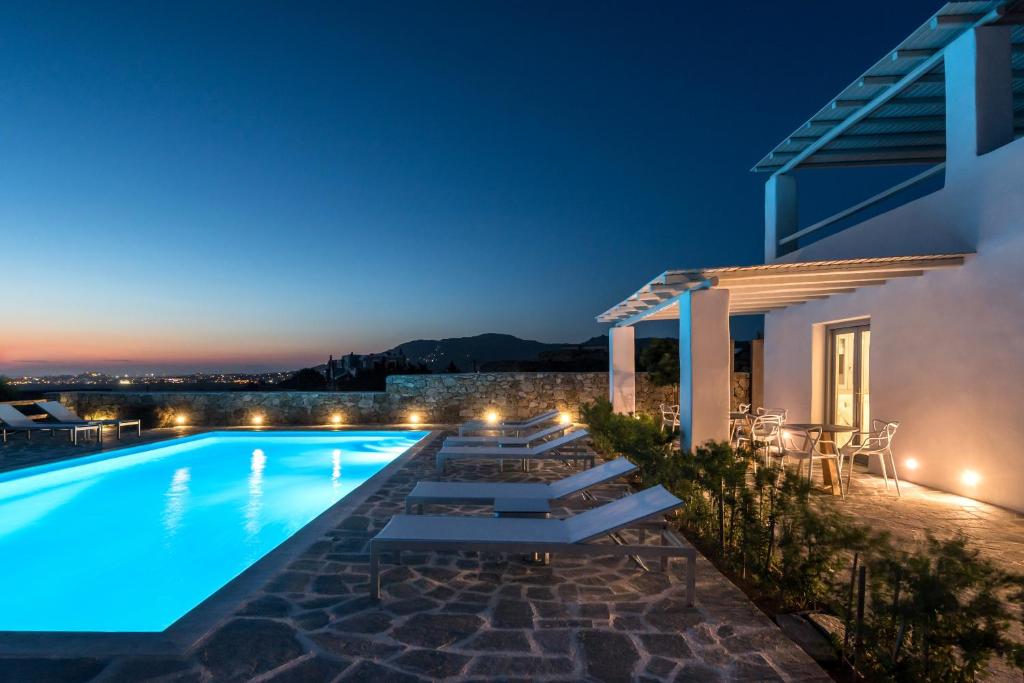 una villa con piscina di notte di Seven Suites a Glinado Naxos