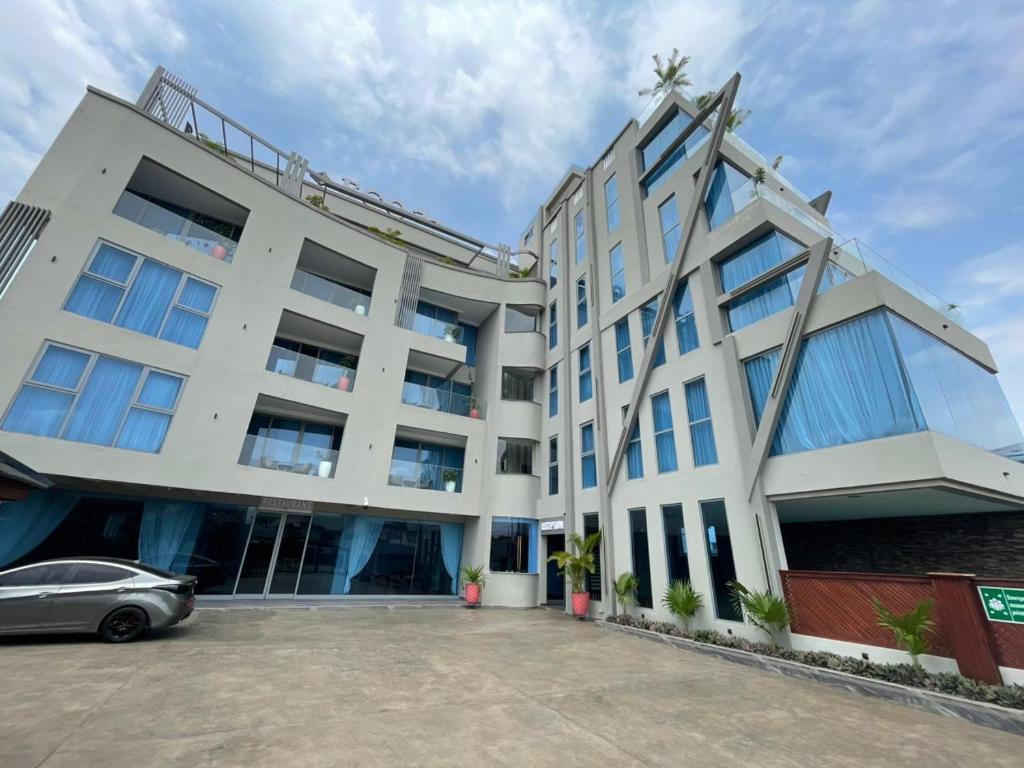 a building with a car parked in front of it at 1bed with pool and restaurant apartment in Accra