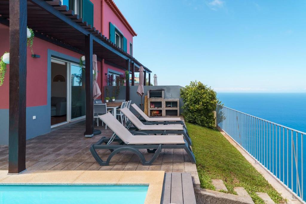 a patio with lounge chairs and a swimming pool at GuestReady - Exquisite stay with sea views in Arco da Calheta