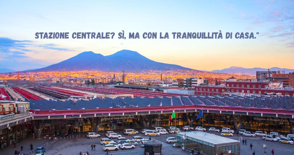 a city with a train station with a mountain in the background at Station House 45 in Naples