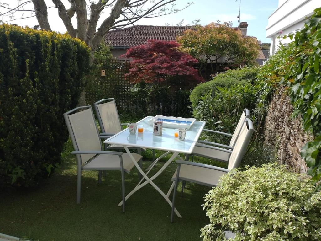 a table and two chairs sitting on the grass at Charmant appartement Pornic in Pornic
