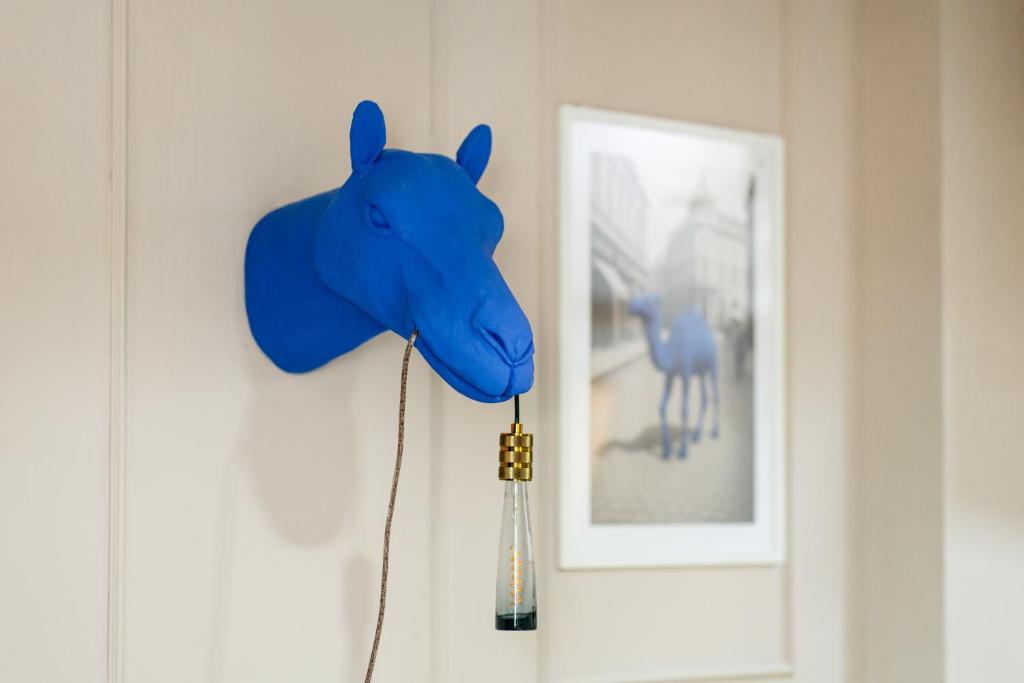 a blue elephant head hanging on a wall next to a picture at Blue Camel in Old Town in Bucharest