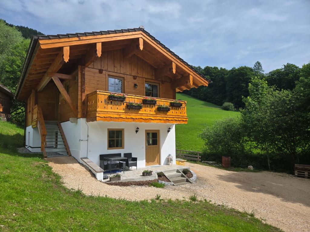 a small house with a wooden roof and a balcony at Klettnerlehen in Ramsau