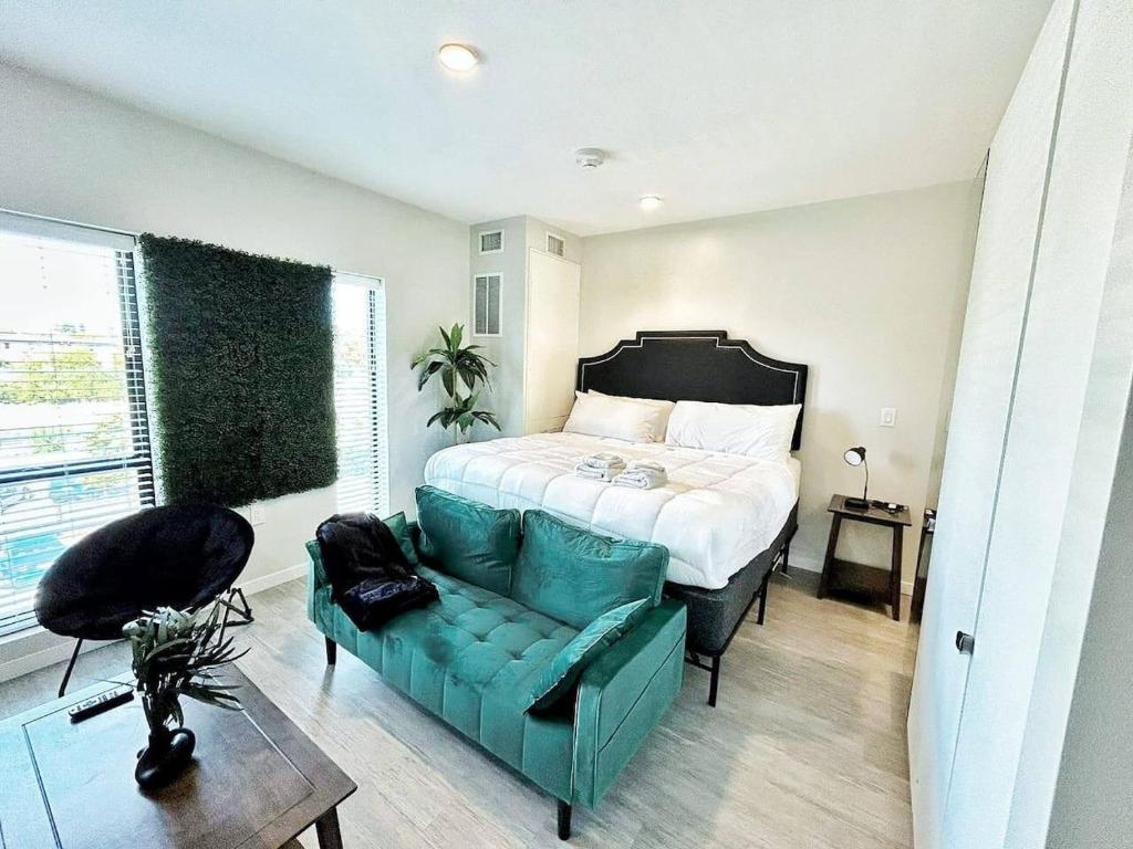 ein Schlafzimmer mit einem Bett und einer grünen Couch in der Unterkunft Aqua Loft in Des Moines