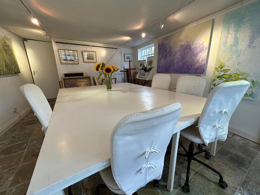 a dining room with a white table and chairs at Cotswolds Retreat in Tewkesbury
