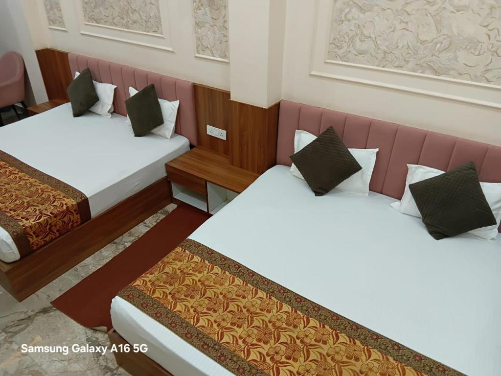 a hotel room with two beds in a room at Darshan Residency in Varanasi