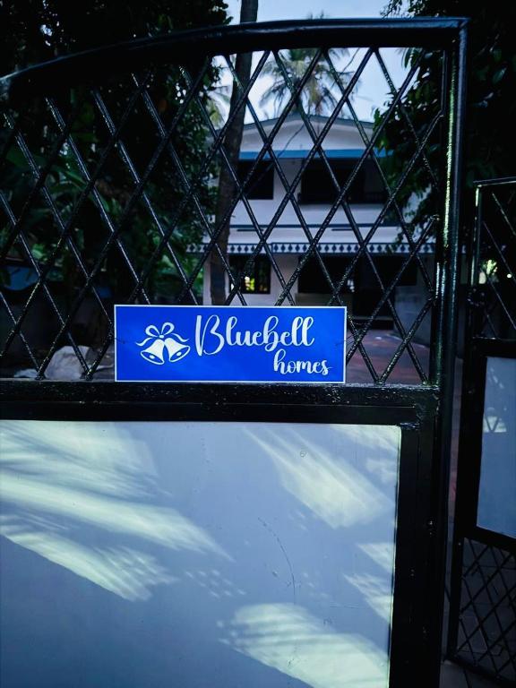 a blue sign on top of a fence at Bluebell Homes Near Beypore Beach Kozhikode in Kozhikode