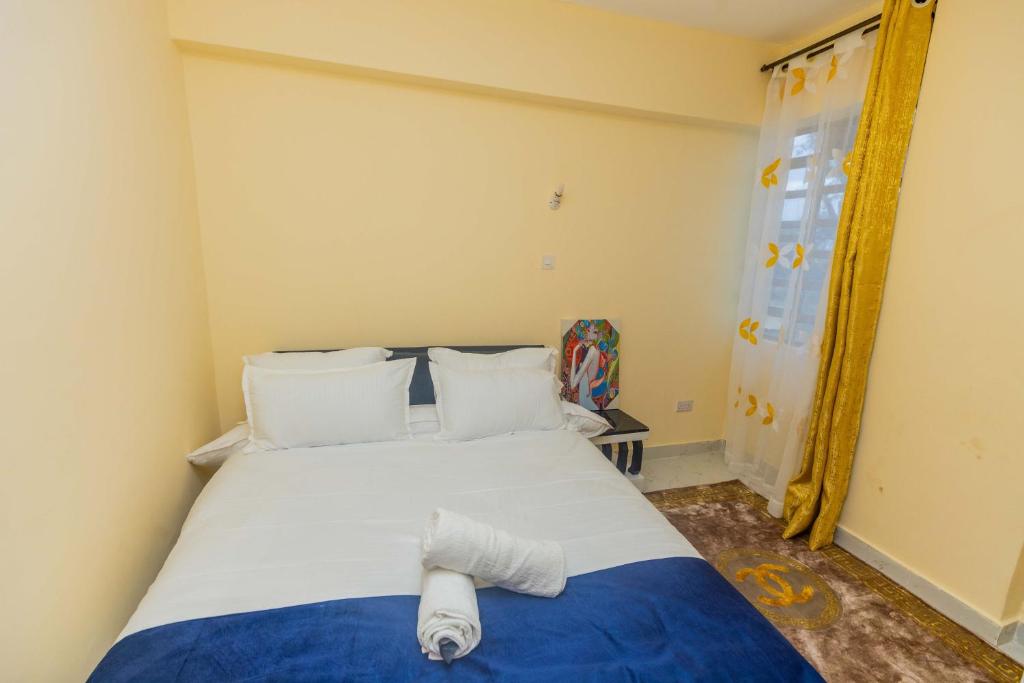 a bedroom with a bed with a towel on it at Marvel Homes in Ruiru