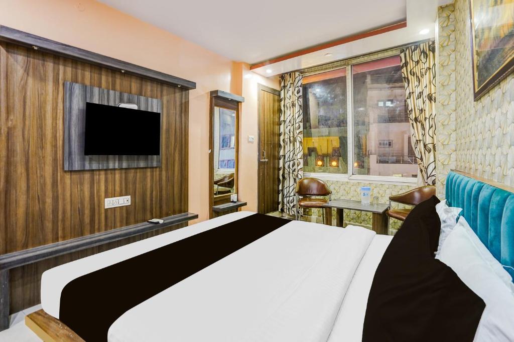 une chambre d'hôtel avec un lit et une télévision dans l'établissement Hotel O Rameshwar Inn, à Prayagraj