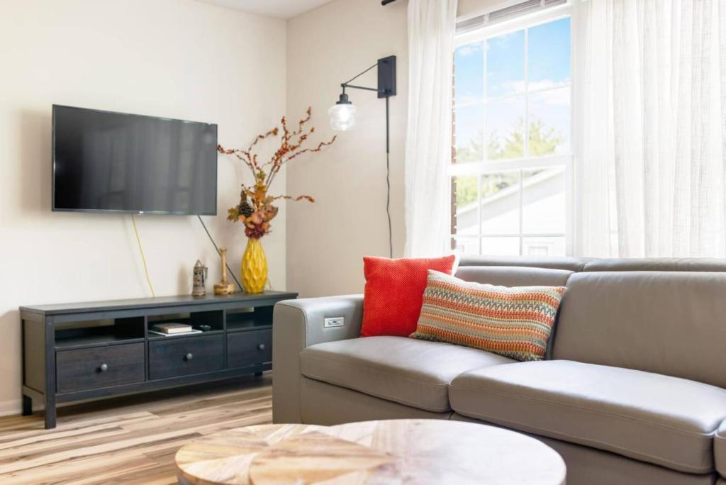 a living room with a couch and a flat screen tv at Cozy Apartment in Downtown Elizabethton in Elizabethton