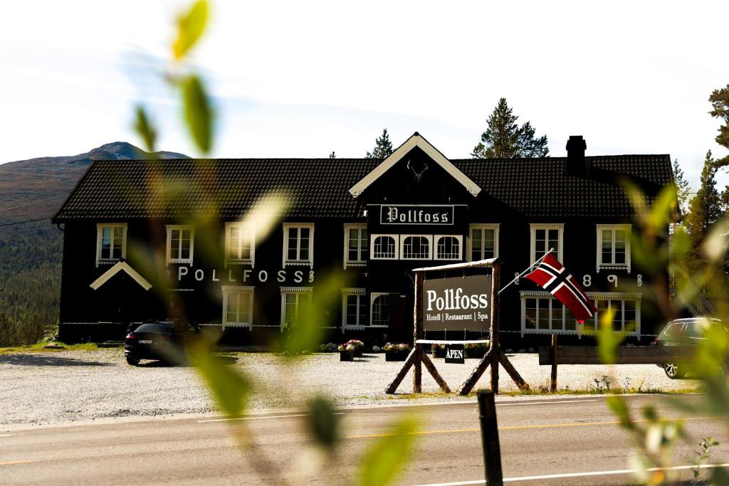 a black building with a sign in front of it at Pollfoss Boutique Hotel & Spa in Skjåk
