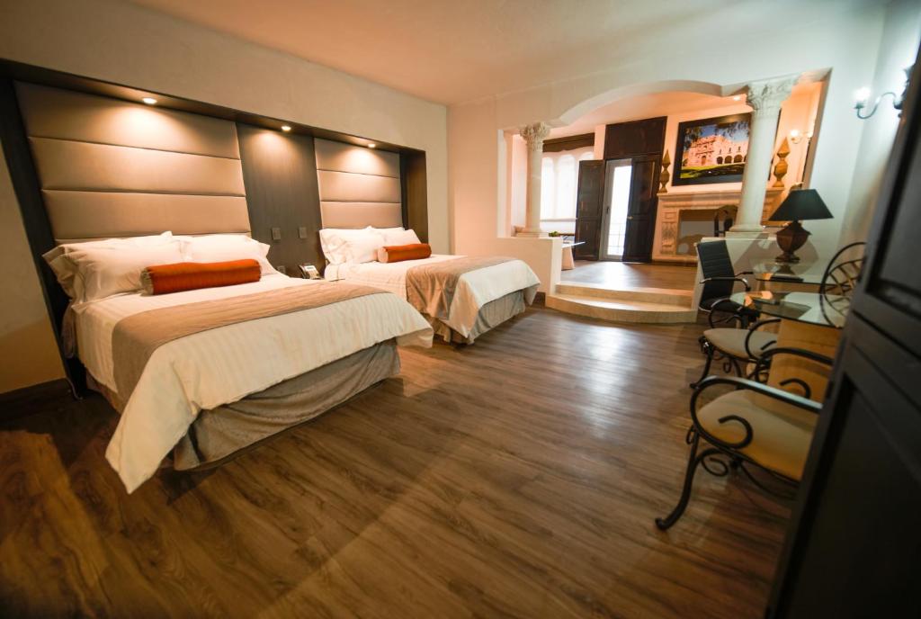 Una habitación de hotel con dos camas y chimenea. en Hotel &amp; Spa Hacienda Baruk, en Zacatecas