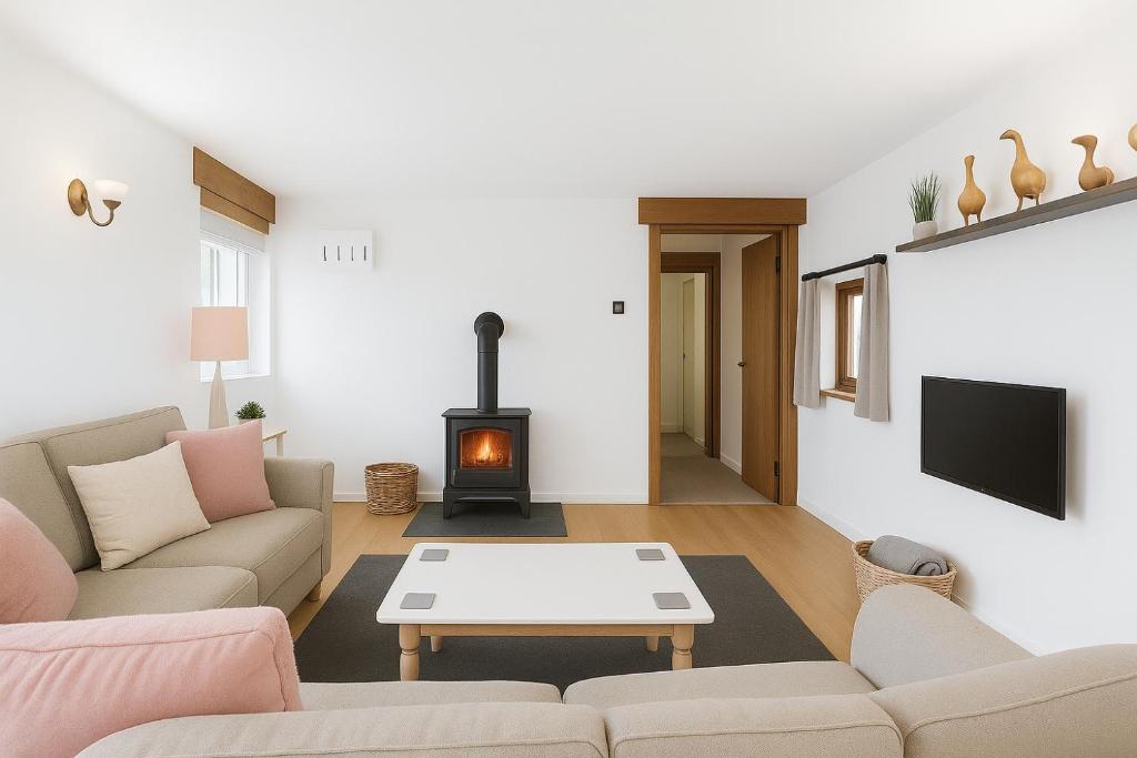 a living room with a couch and a fireplace at Dux Farm Retreat - 2 bed dog friendly cottage, near Bude in Holsworthy