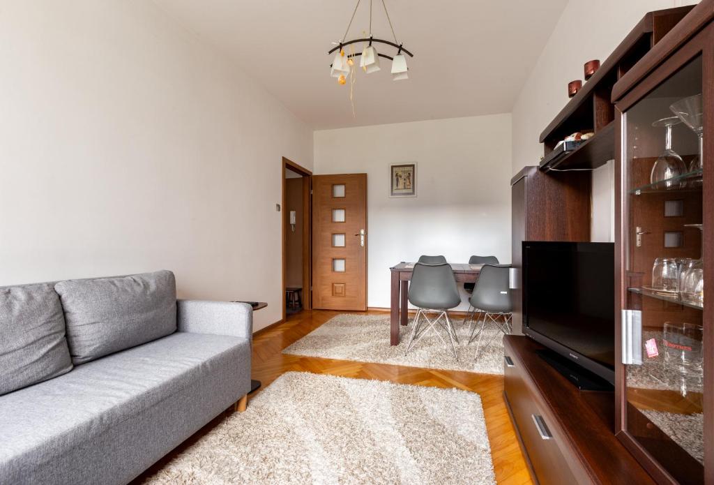 un soggiorno con un divano e un tavolo di Marina Harmony Apartment by BookingHost a Gdynia