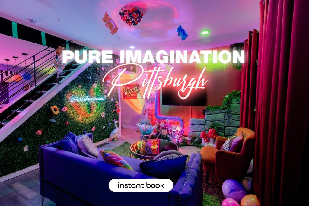 a room with a stage with a neon sign at Famous Willy Wonka Themed Home in Pittsburgh