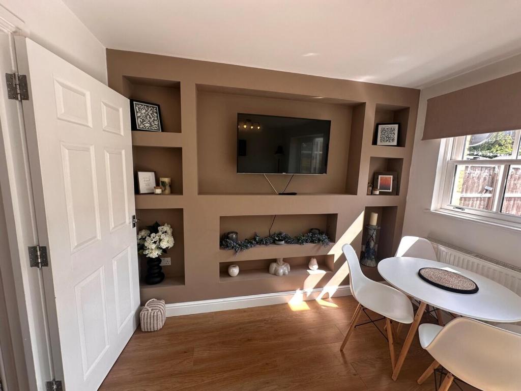 Saint PetersにあるOld Forge Broadstairs with Garden Nr Dreamlandのテーブルと壁掛けテレビのあるダイニングルーム