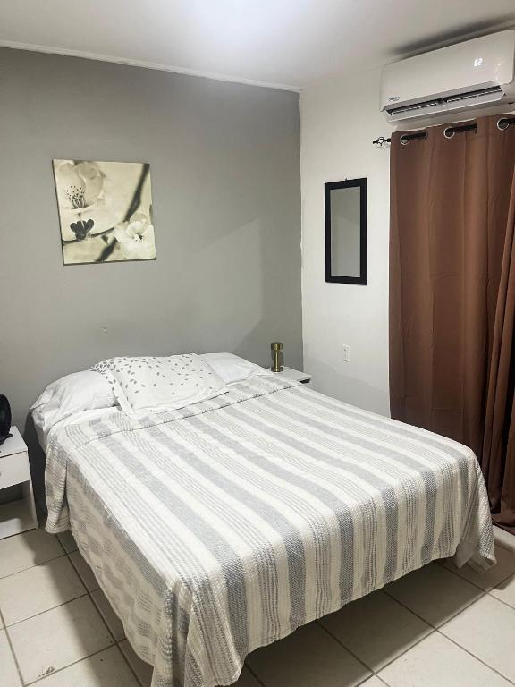 a bedroom with a bed with a striped blanket at The Breeze Villa in Willemstad