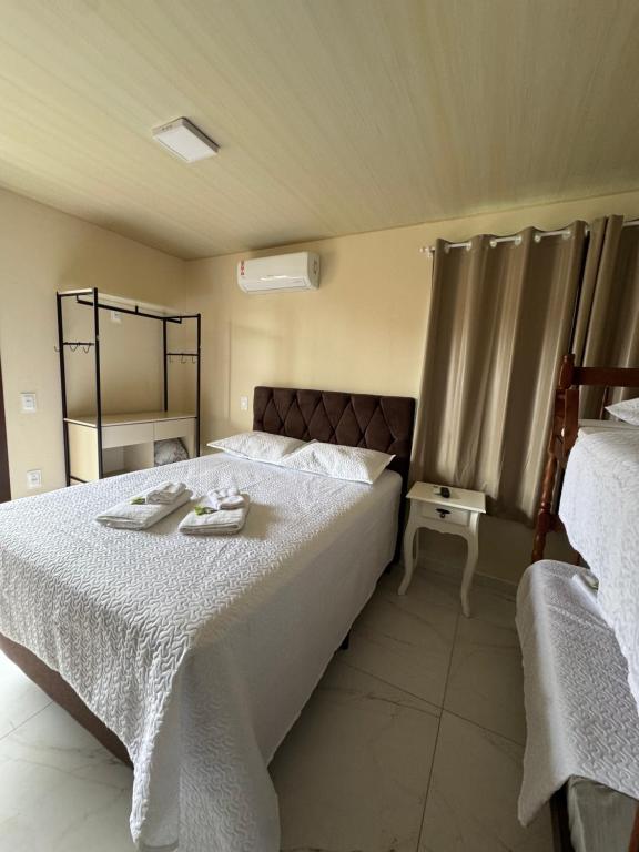 a bedroom with a bed with two towels on it at Residencial Lara 5 in Itapema